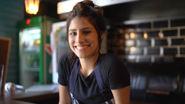 female in navy top smiling - video of who we are